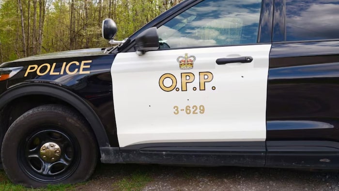 Une voiture de la PPO avec un pneu crevé et des trous de balle.