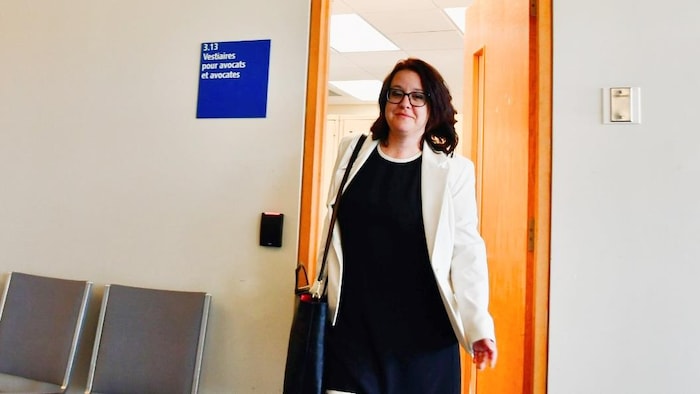 Julie Dufour sort d'une salle du palais de justice.