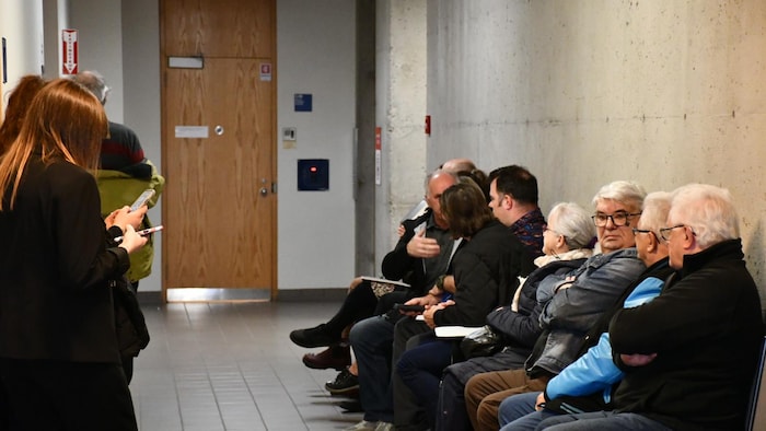 Des personnes assises dans une salle d'attente.