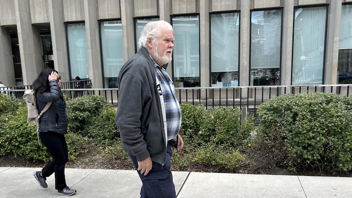 Ron Shute marche sur un trottoir.