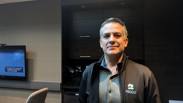 Un homme prend une pose dans son bureau. 