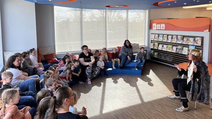 Le personnage de L'Empereur lit une histoire à des enfants à la bibliothèque de Rouyn-Noranda.
