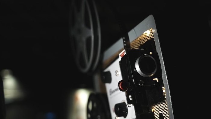 Un projecteur de movie Super 8 en gros program dans un environnement sombre.