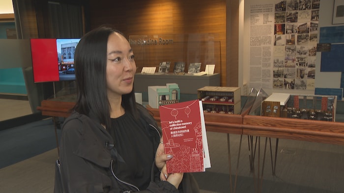 Linda Zhang, présentant le livre qui réunit des histoires partagées lors des sessions.
