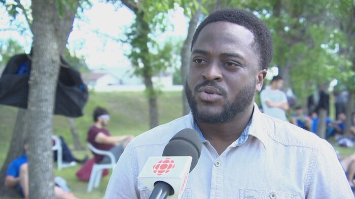 Ephraim Kongolo parle dans un micro lors d'une entrevue le 28 juin 2025 à Gravelbourg.