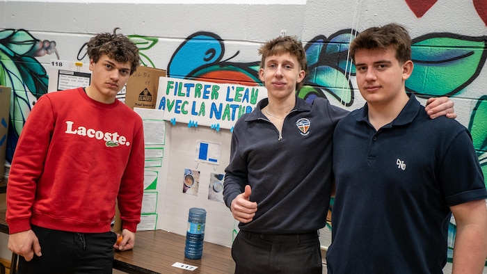 Trois jeunes devant un carton et une bouteille d'eau