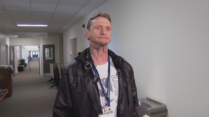 Bryan Kenny se trouve dans un couloir d'université. 