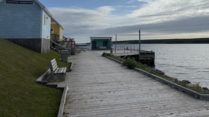 Le ponton en bois est bordé de bancs et de petites maisons.