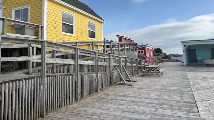 Une rampe en pente légère permet d'accéder à des tables de pique-nique et un abri posés sur le quai en bois large de plusieurs mètres.