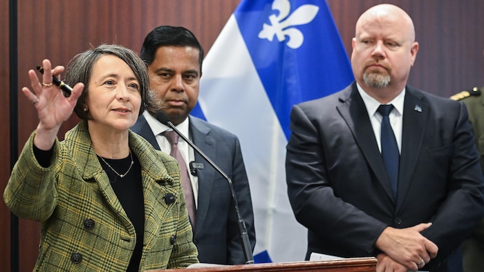 Trois personnes derrière un lutrin en conférence de presse.