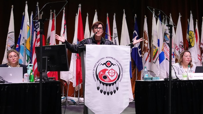 Cindy Blackstock les bras en l'air s'adressant à la foule. 
