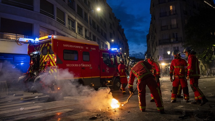 Des pompiers en train d'intervenir sur les lieux d'un incendie de batterie de vélo. 