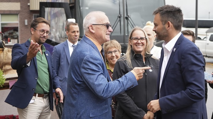 Deux hommes parlent face à face.