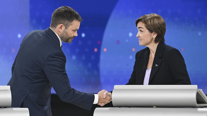 Paul St-Pierre Plamondon et Christine Fréchette se serrent la main derrière leurs pupitres.