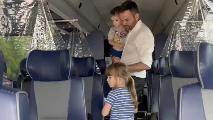Un homme avec deux jeunes enfants dans un autocar