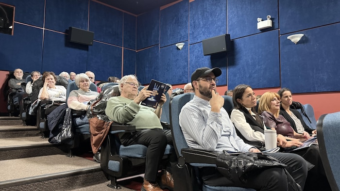 Des personnes assises dans une salle de cinéma assistent au dévoilement de la programmation du festival Cinoche.
