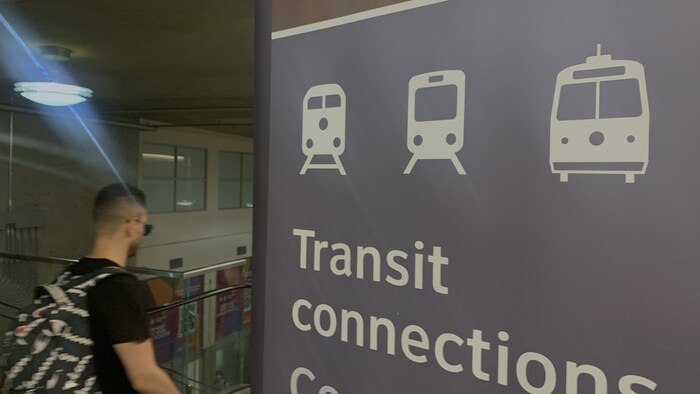 Logo ng Toronto Transit Commission habang makikita ang isang babae na pasakay ng tren. 