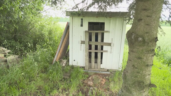 Un puits est entouré d'un cabanon fait de tôle de métal.