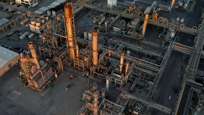 Vue aérienne d'une raffinerie avec un enchevêtrement de tuyaux d'acier.