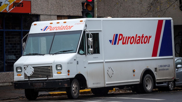 Un camion de Purolator stationné dans une rue.