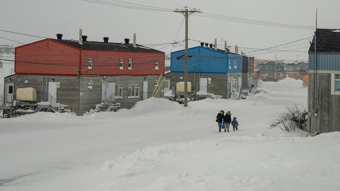 Des gens marchent dans une rue aux maisons colorées.