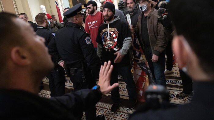 L'homme a un t-shirt avec un logo en forme de Q.