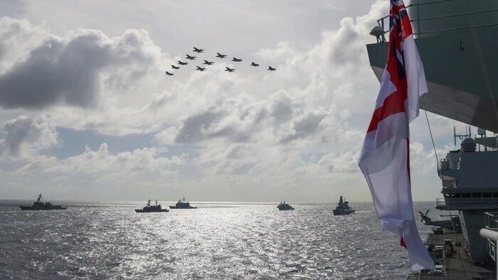 U.S. and U.K. F35B Lightning Jet and U.S. F-18 fighter jets fly past in formation over (left to right) USS Chafee, JS Yamagiri, USS Lake Champlain, HMCS Winnipeg and HMS Defender on October 3, 2021.
