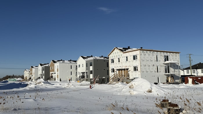 Plusieurs immeubles en rangées sur un chantier de construction.