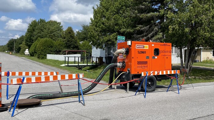 Une machine qui a des tuyaux jusque dans un puisard, dans la rue.