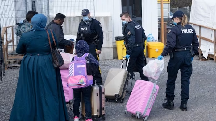 Police officers accompany a Muslim family.