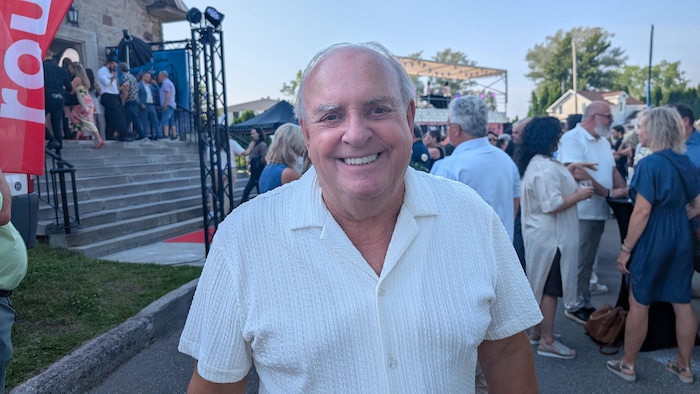 Robert Doré sourit devant une foule.