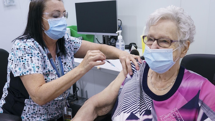 Gisele Fortaich, 86, receives her first dose of COVID-19 vaccination from nurse Renee Bourassa in Laval, Que. on Thursday, February 25, 2021, marking the start of mass vaccination in the province of Quebec. THE CANADIAN PRESS/Paul Chiasson