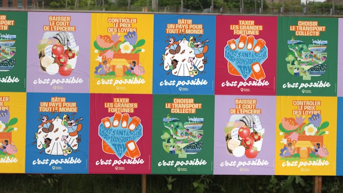 Les affiches de Québec solidaire collées sur un mur à l'extérieur.