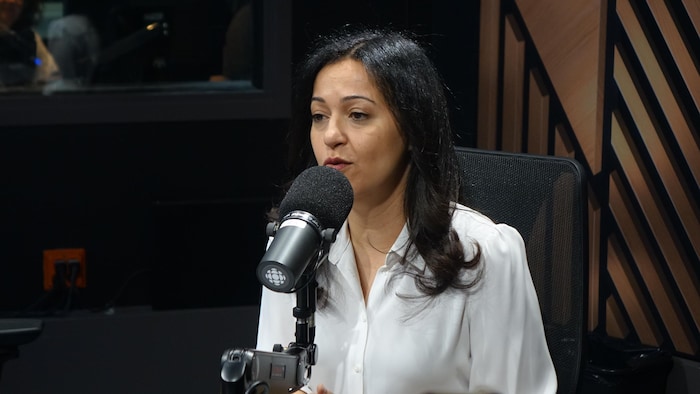 Une femme assise dans un studio radio.