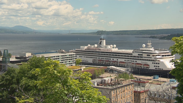Un bateau de croisière amarré à Québec avec une vue sur le fleuve vers l'île d'Orléans