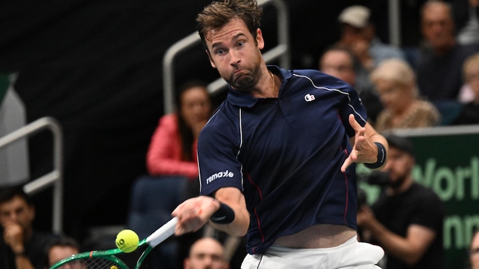 Un joueur de tennis s'apprête à frapper la balle sur son coup droit. 