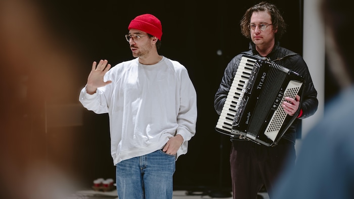 Deux hommes dont l'un transporte un accordéon.