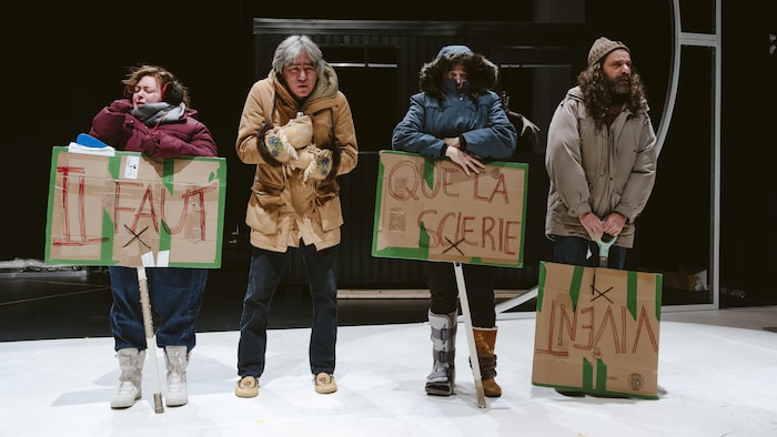 quatre personnes avec des pancartes.