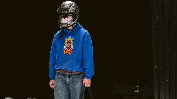 Un homme sur scène avec un casque de moto.