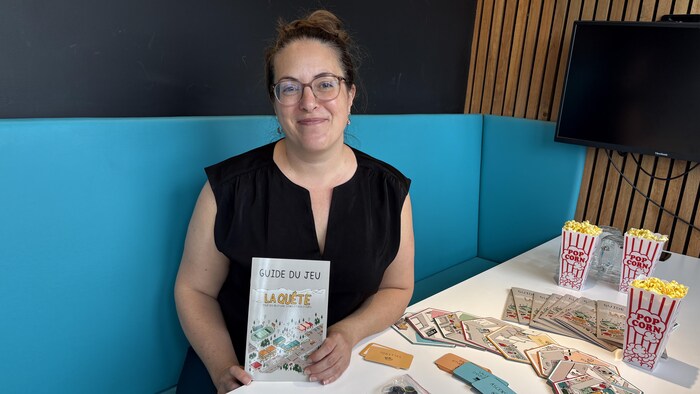 Marie-Ève Blackburn tient le guide du jeu de société.