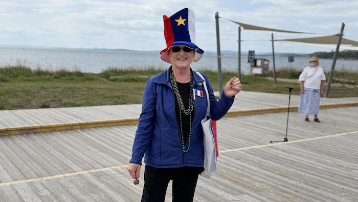 Marthe Chandler est habillée de la tête au pied à aux couleurs du drapeau acadien, soit le bleu, le blanc et le rouge.