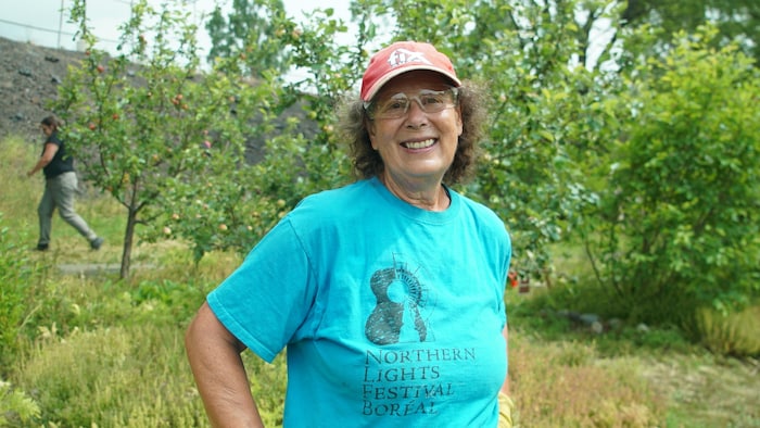 Rachelle Niemela posant dans un jardin arborant des lunettes de travail et une casquette de baseball.