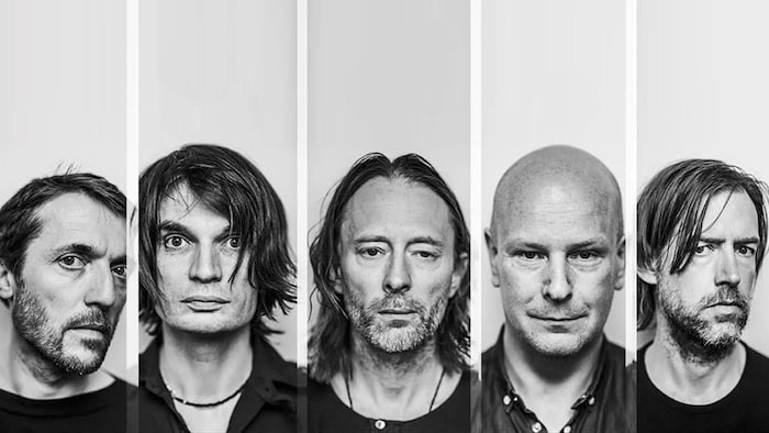 Portrait des cinq membres du groupe en noir et blanc.