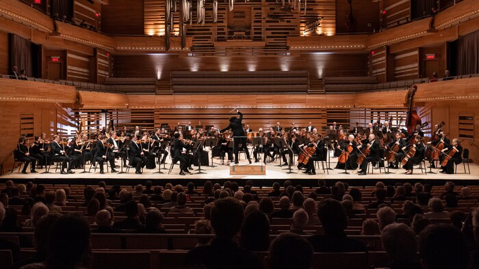 Le chef dirige son orchestre devant le public.