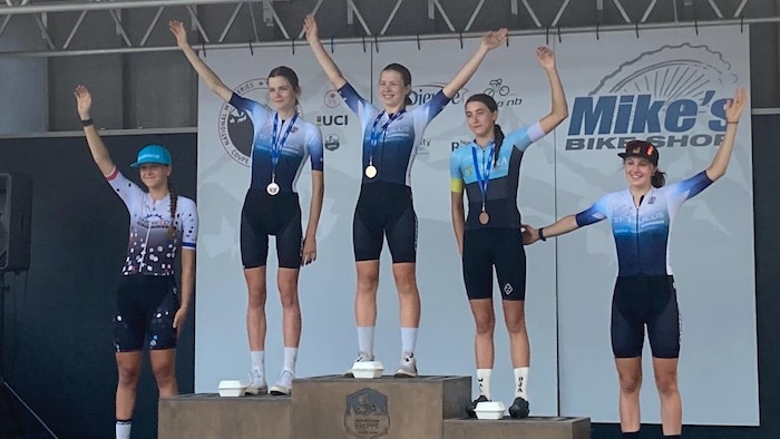 Les trois athlètes sur le podium entourées des 4e et 5e finissantes de la course.