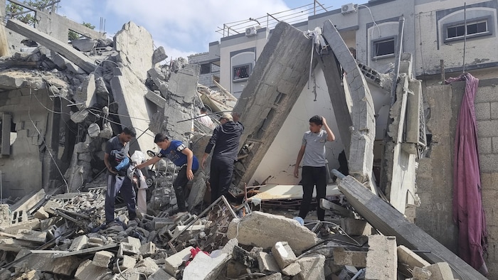 Des jeunes Palestiniens fouillent les décombres de leur demeure de Rafah à la recherche de biens personnels.