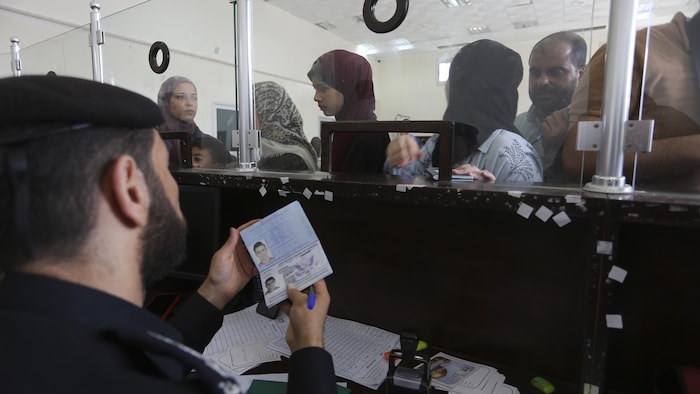 موظف فلسطيني عند معبر رفح يتفحص وثائق سفر مواطنين أجانب سُمح لهم بالخروج من قطاع غزة.