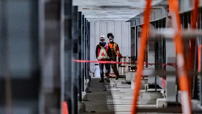 Deux employés à l'intérieur d'un bâtiment.