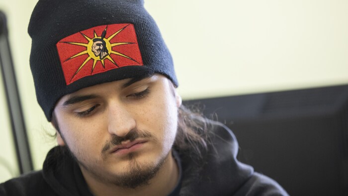 Un jeune homme avec une tuque arborant le drapeau des Warriors.