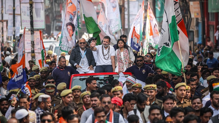 Rahul Gandhi est assis dans un jeep ouvert, entouré d'une foule agitant des drapeaux.